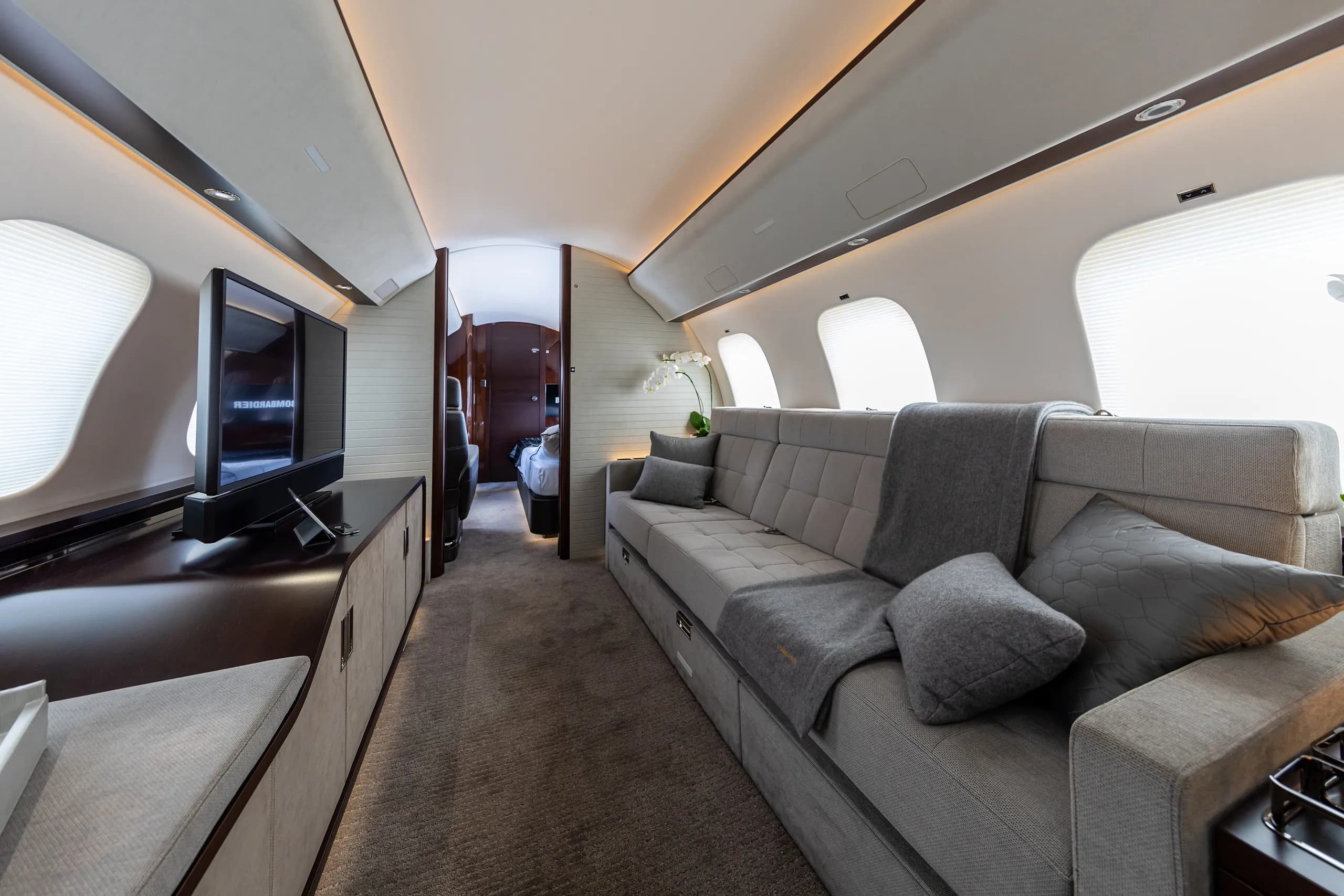 The lounge of a Bombardier Global 7500, with a long sofa and wide windows