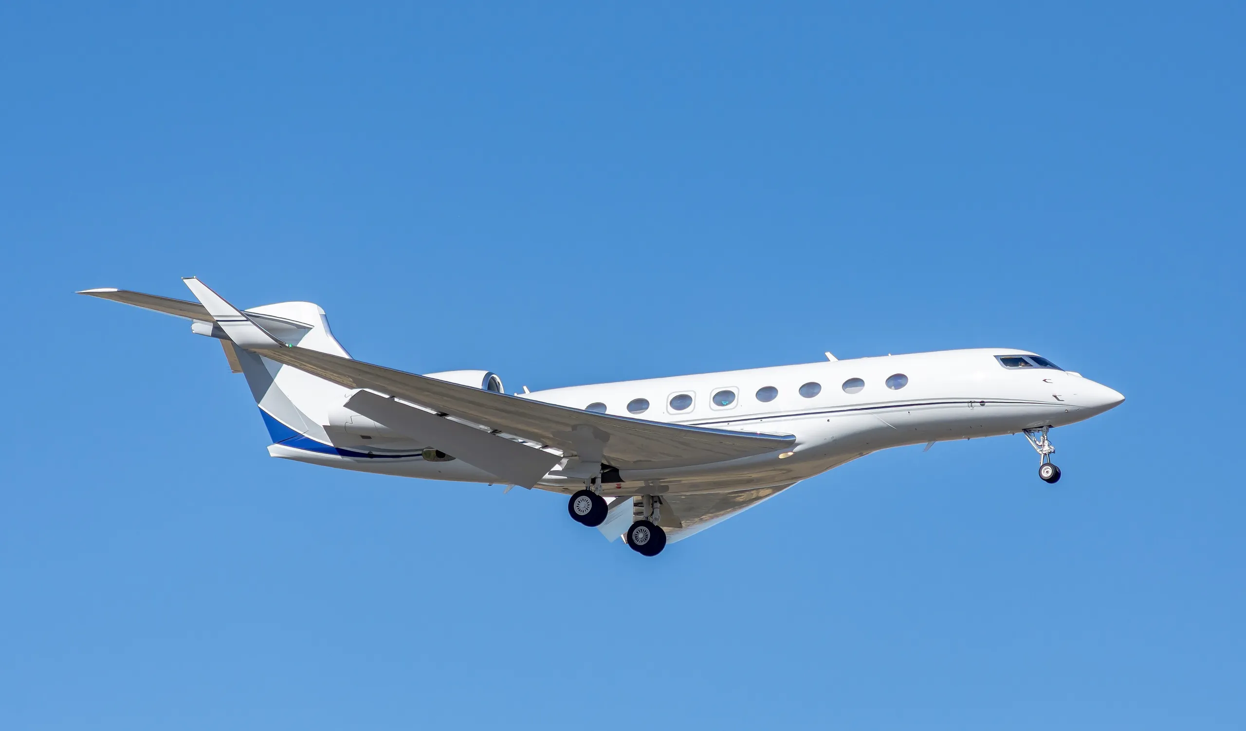 A Gulfstream G650 on approach under a clear sky